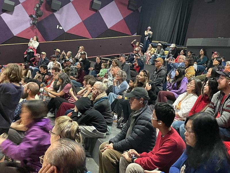 A seated audience enjoys the performances